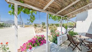 a patio with flowers and a table and chairs at Firiki Studios in Zefiría
