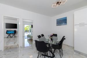 a dining room with a glass table and black chairs at Casa Joy in Premantura