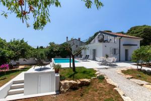 a villa with a swimming pool and a house at Casa Joy in Premantura