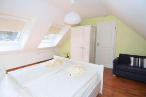 Un dormitorio con una cama blanca y una silla negra. en Wendstraße 10, Ferienhaushälfte, en Heiligenhafen