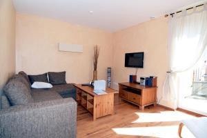 Una sala de estar con un sofá y un televisor. en Wendstraße 10, Ferienhaushälfte, en Heiligenhafen