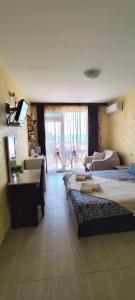 a bedroom with two beds and a desk and a sink at Aqua Studio - Sveti Vlas in Sveti Vlas