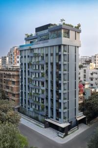 a tall white building with trees on top of it at W Residence Living in Dhaka