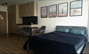 a bedroom with a bed and a table with chairs at Butas su terasa in Šventoji +4 photos