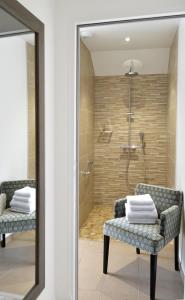 łazienka z prysznicem, 2 krzesłami i lustrem w obiekcie La Maison de Mathilde w mieście Bayeux
