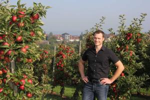 a man standing in front of an apple orchard at Gaestehaus Zum Wolffenturm in Lehrensteinsfeld