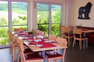 a dining room with a table and chairs and windows at Gaestehaus Zum Wolffenturm in Lehrensteinsfeld