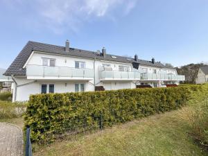 a white house on top of a hedge at Haus Sanddorn - Whg 4 in Thiessow