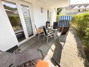 a patio with chairs and a table on a porch at Haus Sanddorn - Whg 4 in Thiessow +22 photos