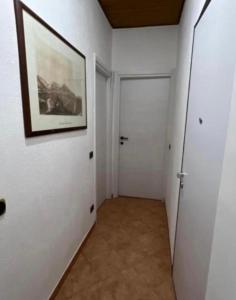 einen Flur mit einem Gemälde an der Wand und einer Tür in der Unterkunft Aurora home in Mailand