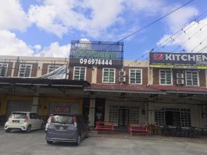 a building with two cars parked in a parking lot at OYO 90473 Opah Inn Hotel in Jertih