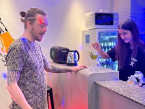 a man and a woman preparing a drink at a counter at The LODGE BKK Hostel in Bangkok