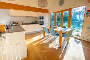 a kitchen with a wooden table and chairs at House 30 in Looe