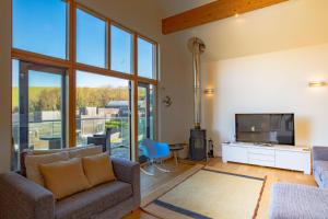 a living room with a couch and a flat screen tv at House 30 in Looe