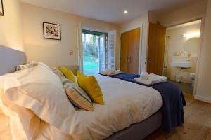 a bedroom with a large white bed with yellow pillows at House 30 in Looe +23 photos