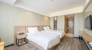 Postel nebo postele na pokoji v ubytování Borrman Hotel Xiamen Xiang'an Maxiang