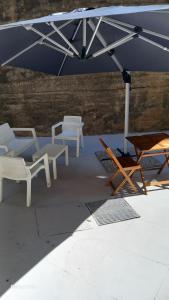 un groupe de tables et de chaises sous un parapluie dans l'établissement La casa di Fabia - Home suite, à Messina 9 autres photos