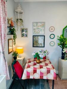 a dining room with a table with flowers on it at 43 Digbeth Private Studio Apart in Birmingham