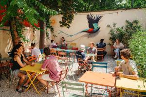 a group of people sitting at tables in a restaurant at YASI Hostel in Lyon