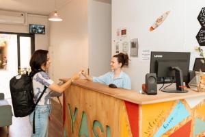 two women shaking hands at a reception desk at YASI Hostel in Lyon