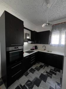 a kitchen with black cabinets and a white counter top at Aegean Breeze in Lilikás