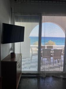 a living room with a sliding glass door with a view of the ocean at Aegean Breeze in Lilikás +4 photos