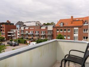 a balcony with two chairs and a view of a city at Traum-Ferienwohnung Mozart ! in Wilhelmshaven
