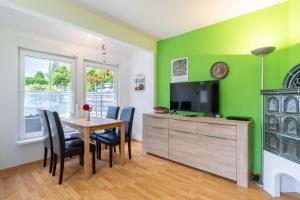 a dining room with green walls and a table and chairs at Ferienhaus Knospe in Ueckeritz
