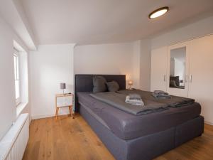 a bedroom with a large bed in a white room at Traum-Ferienwohnung Mozart ! in Wilhelmshaven
