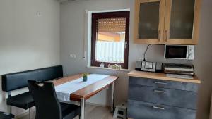 cocina pequeña con escritorio y microondas en Ferienwohnung Denninger,  3 fotos más