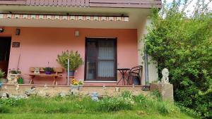 Una pequeña casa rosa con una mesa y una silla. en Ferienwohnung Denninger, 