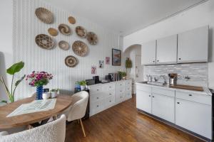 een keuken met witte kasten en een houten tafel bij Union Square Sanctuary - Chic One Bedroom Retreat in Downtown Manhattan in New York