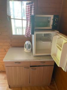 a small kitchen with a microwave on top of a counter at Autocamp Free Star - Chatky a Bungalovy in Strachotín