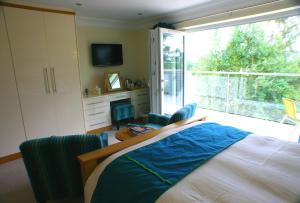 Schlafzimmer mit einem Bett und einer Glasschiebetür in der Unterkunft Stoke Gabriel Lodgings in Totnes
