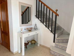 una escalera con una mesa blanca y un espejo en Casa Rubio, en Chiclana de la Frontera 15 fotos más