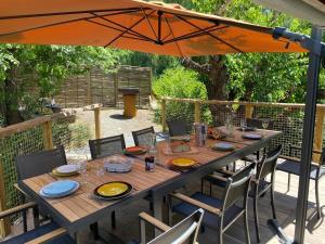 Chalet - Les Fermes de Céline - Barcelonnette في Enchastrayes: طاولة خشبية مع كراسي ومظلة