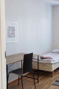 a desk and a chair in a room with a bed at Apartment Vanhatie, 3mh in Pyhäjoki +6 photos