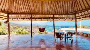 a patio with a hammock hanging from a roof at Yoga bale house in Padangbai