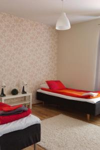 a bedroom with two beds with red pillows at Apartment Vanhatie, 3mh in Pyhäjoki