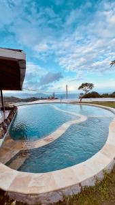 a large pool of water with a bridge in the background at Yoga bale house in Karangasem