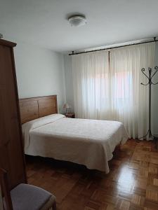 Un dormitorio con una cama blanca y una ventana. en Casa Montse-Izquierda, en Colombres