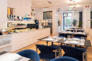 a restaurant with tables and chairs and a kitchen at Hotel Luxe in Split