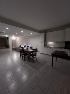 a living room with a table and chairs and a kitchen at Demetra Bed in Lizzanello