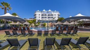 a group of chairs and umbrellas next to a pool at Sisus Marina Hotel in Çeşme