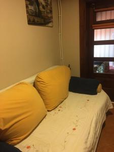 a bed with two yellow pillows on top of it at Willa Sara in Okuninka