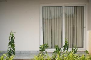 a white house with a window with plants in front of it at Simbaa Resorts and Conventions  +2 photos