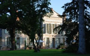 um grande edifício branco com árvores em frente em Côté Park em Givry