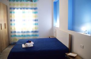 sypialnia z niebieskim łóżkiem z pluszakiem w obiekcie A Mare Appartamenti w mieście Castellammare del Golfo