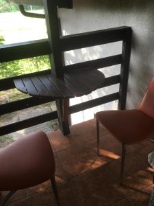 a bench and two chairs in front of a window at Willa Sara in Okuninka