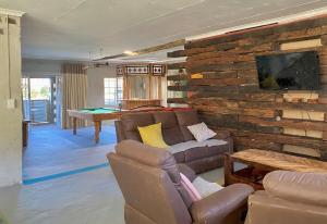 a living room with a couch and a pool table at Little Rock Inn in Somerset East